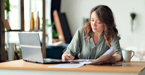 woman sitting at a desk in front of her laptop